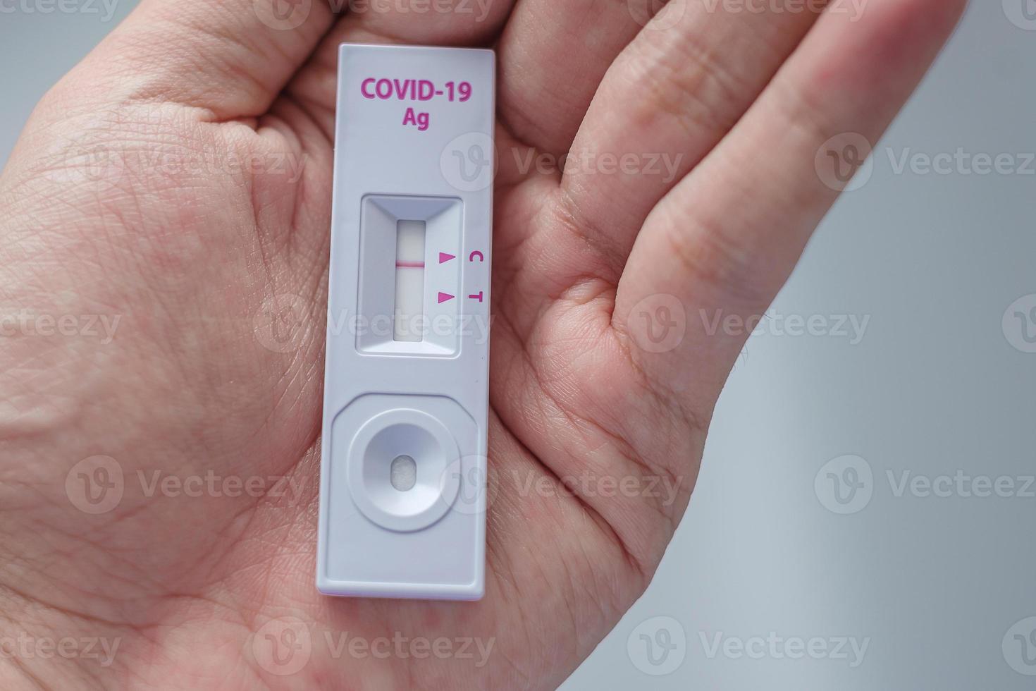 uomo che tiene un kit per il test rapido dell'antigene con risultato negativo durante il test del tampone covid-19. coronavirus auto nasale o test domiciliare, blocco e concetto di isolamento domiciliare foto