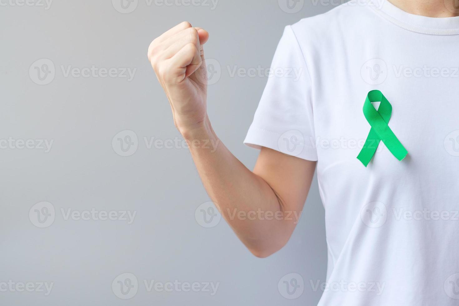 nastro verde per il mese di sensibilizzazione del fegato, della cistifellea, del dotto biliare, del collo dell'utero, del cancro ai reni e del linfoma. concetto di salute e giornata mondiale del cancro foto