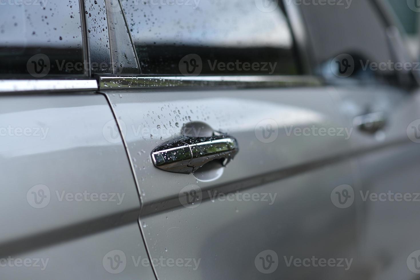 mani sul lato dell'auto e gocce d'acqua. foto