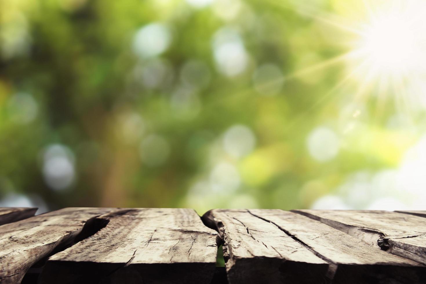 legno vuoto con sfocatura albero bokeh e sfondo del sole foto