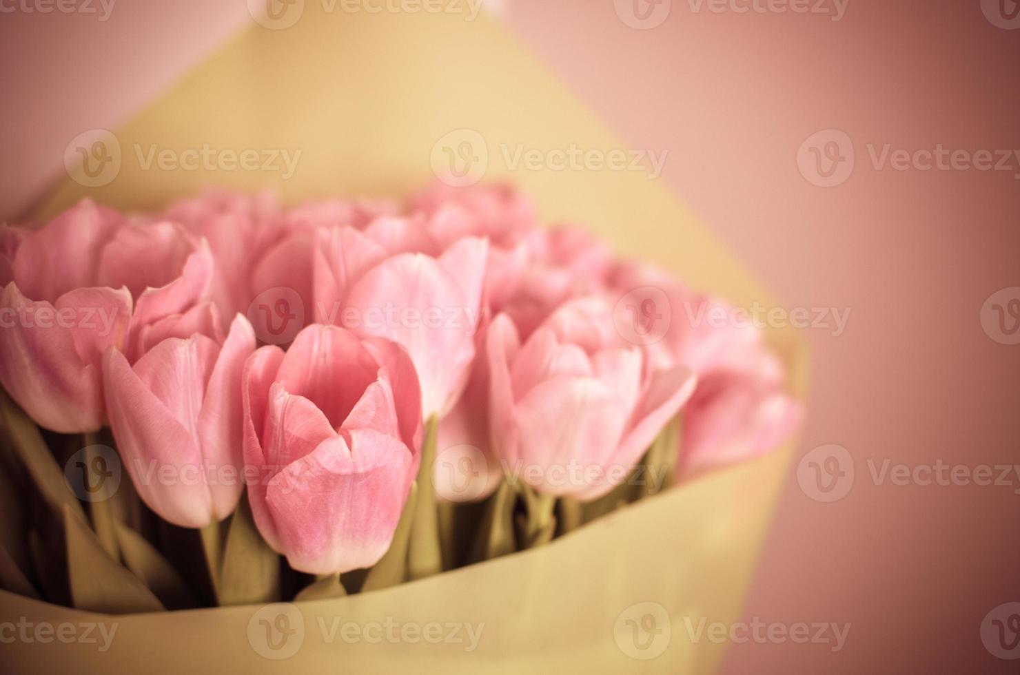 bouquet di fiori di tulipani con tulipani rosa in carta verde foto