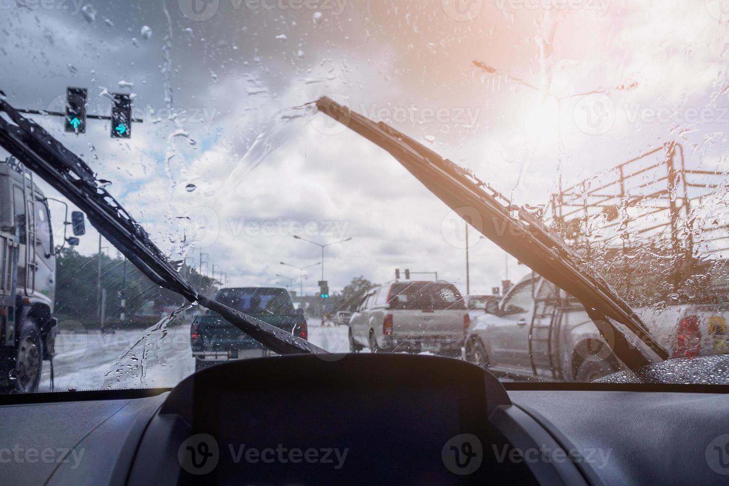 traffico in una giornata di pioggia intensa con vista sulla strada all'interno del finestrino dell'auto con gocce di pioggia foto