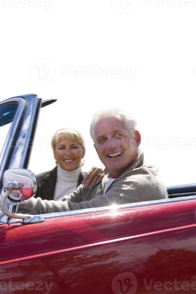 coppia senior seduto in macchina rossa aperta, ritagliata foto