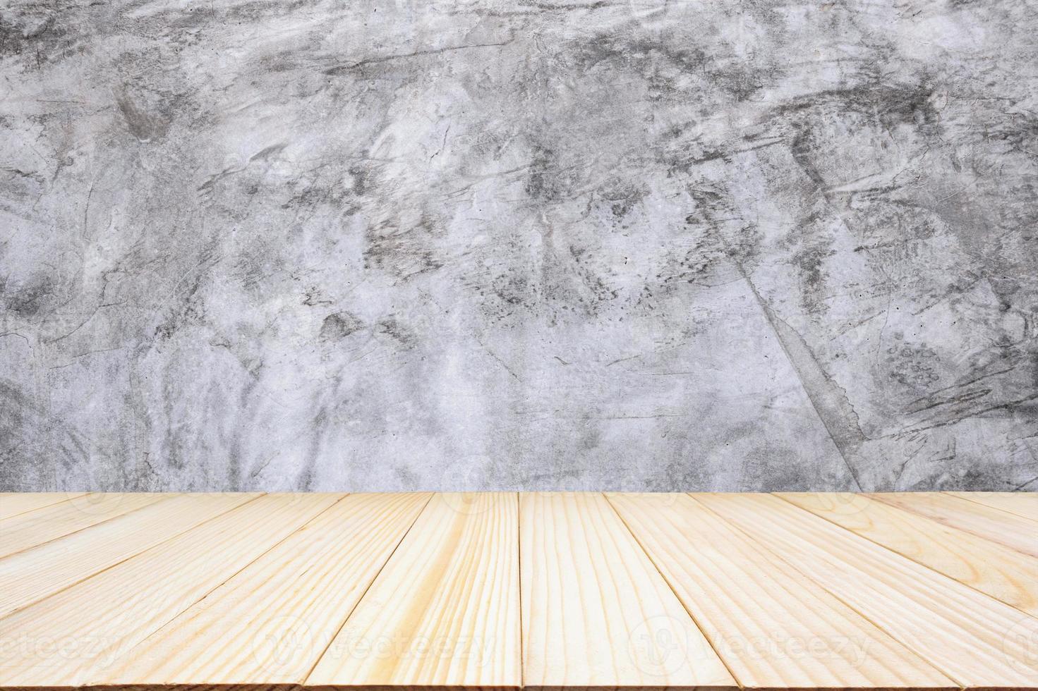 piano del tavolo in legno con sfondo muro di cemento foto