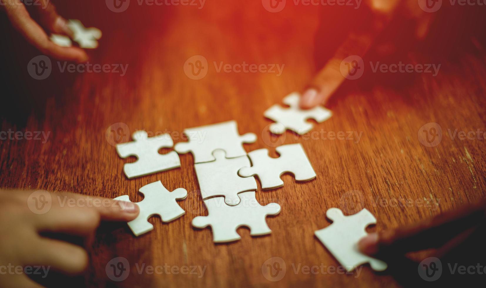 concetto di unità e cooperazione di lavoro di squadra mano che tiene il puzzle primo piano pezzo di mano che collega puzzle collegati tra loro soluzione aziendale concetti e strategie di successo foto
