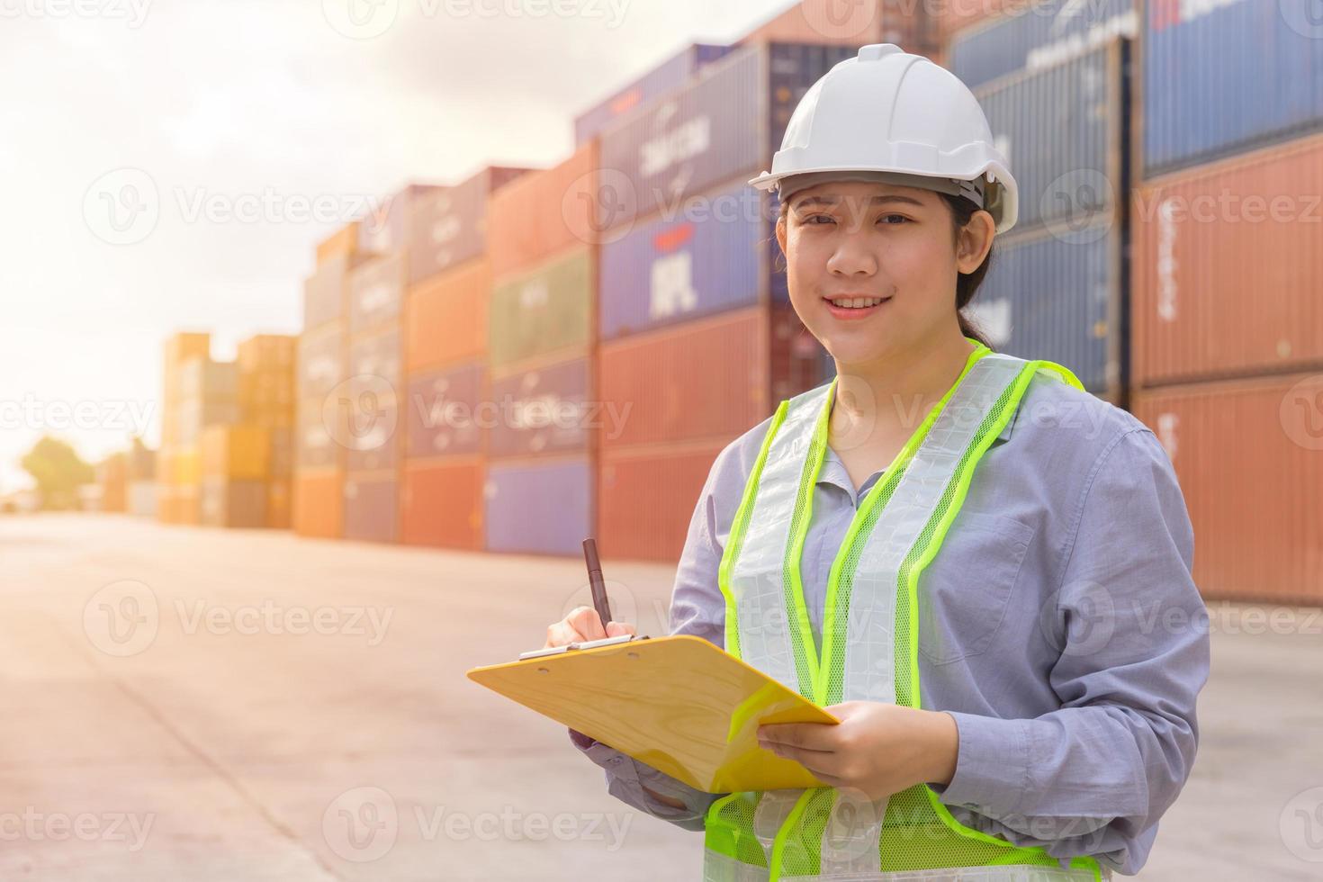 asiatico giovane adolescente felice lavoratore che controlla le scorte nel porto di spedizione il lavoro gestisce i contenitori di carico per l'importazione e l'esportazione. foto