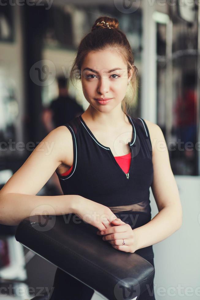 giovane donna in palestra utilizzando attrezzature per il fitness foto