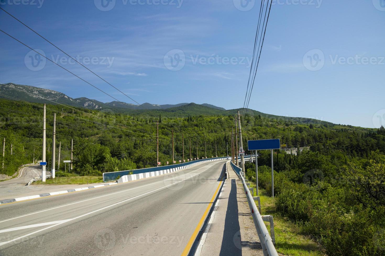 ponte automobilistico con una strada asfaltata che passa attraverso un fiume europeo di montagna. foto