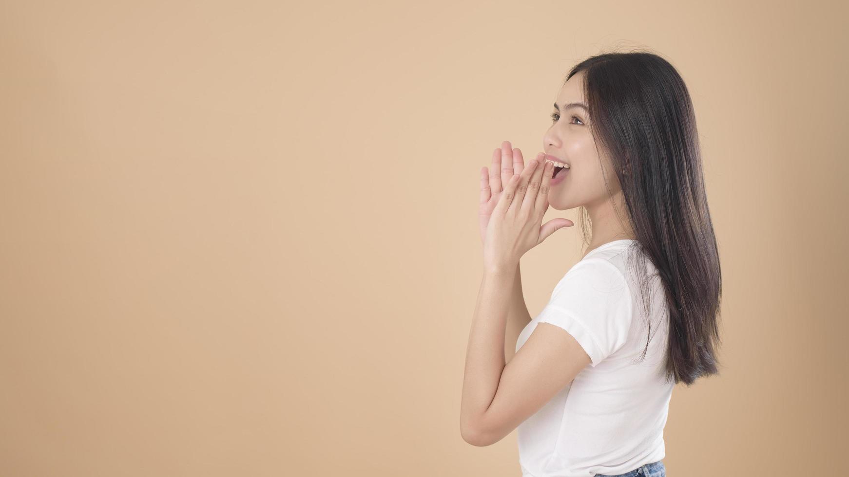 un ritratto di donna asiatica con t-shirt bianca su sfondo marrone chiaro studio foto