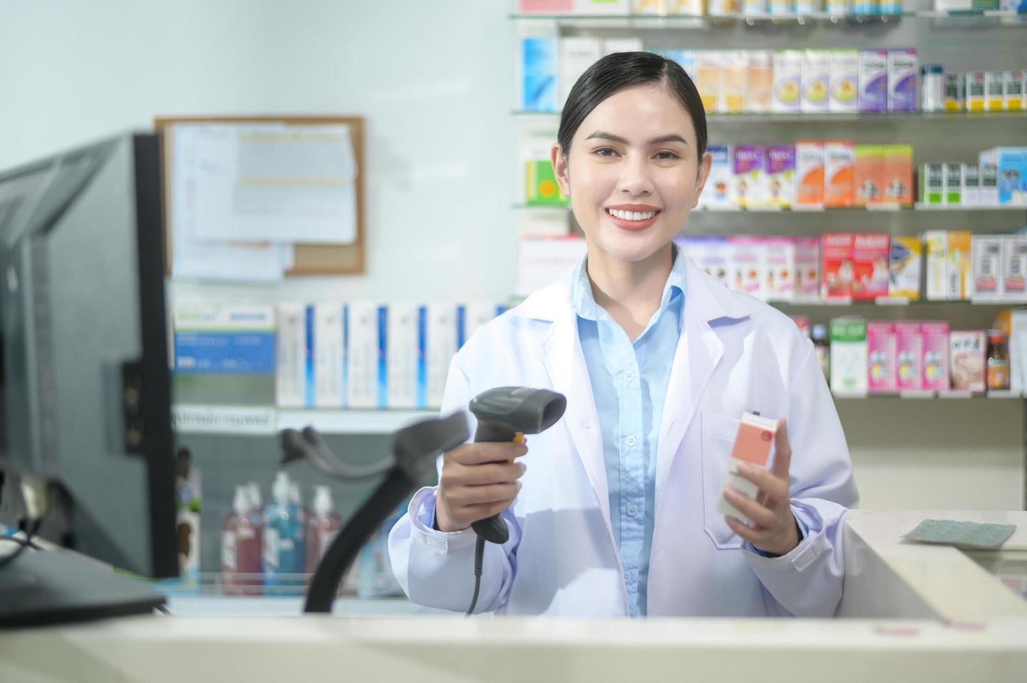 farmacista femminile che scansiona il codice a barre su una scatola di medicinali in una moderna farmacia. foto