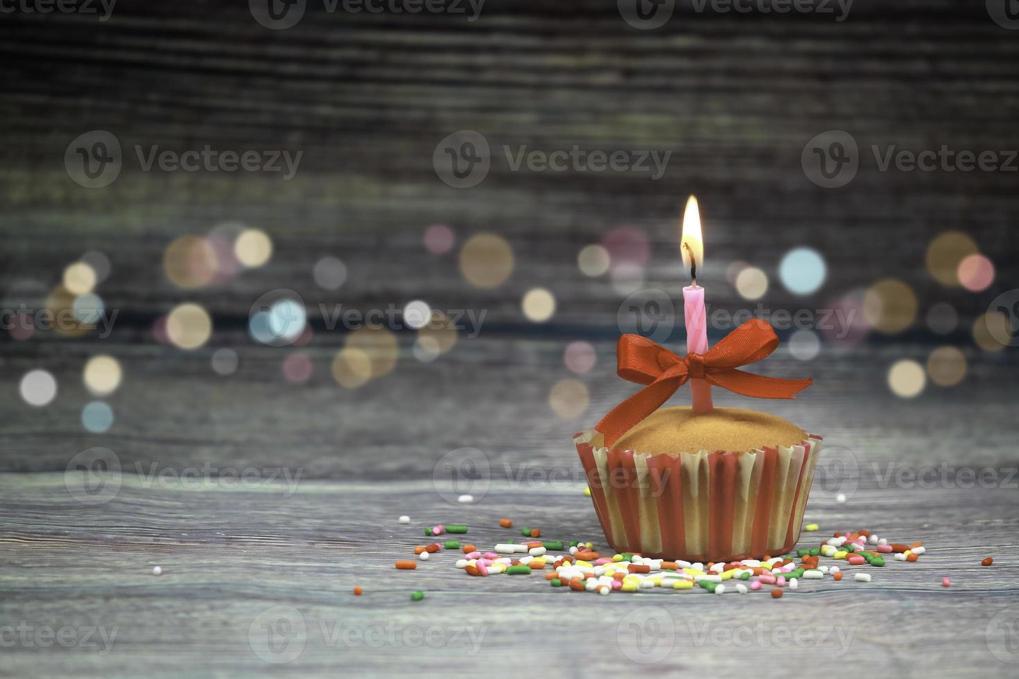 Cupcake di buon compleanno e candela di prua sul tavolo su sfondo di legno con spazio per la copia. concetto di sfondo di buon compleanno cibo carino foto