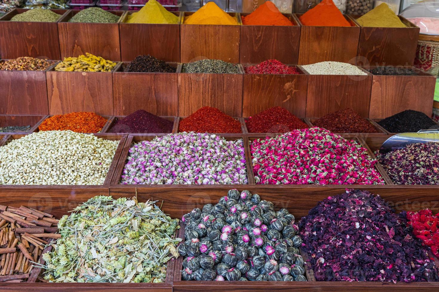 primo piano di belle file di spezie fresche curcuma, cumino, pepe rosso e nero, prezzemolo, peperoni, verdure, carote, cipolle. varie spezie sulla vetrina del mercato foto