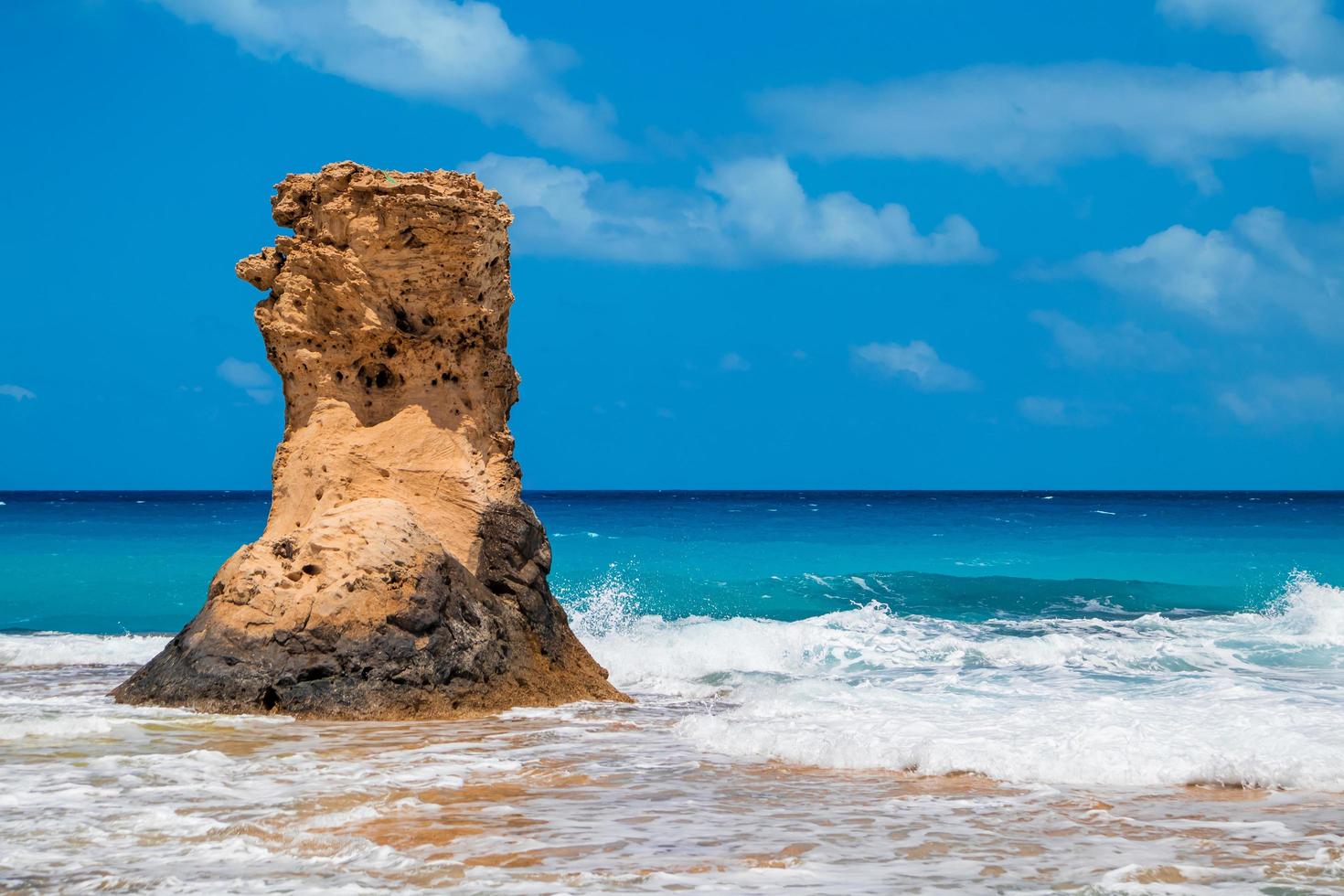 grande pietra alta nella carta da parati del mare foto