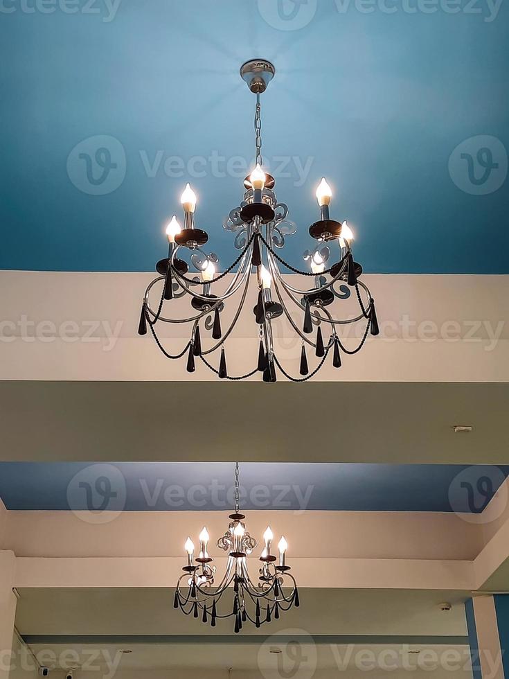 lampadario con lampade a forma di candele su un soffitto blu. foto