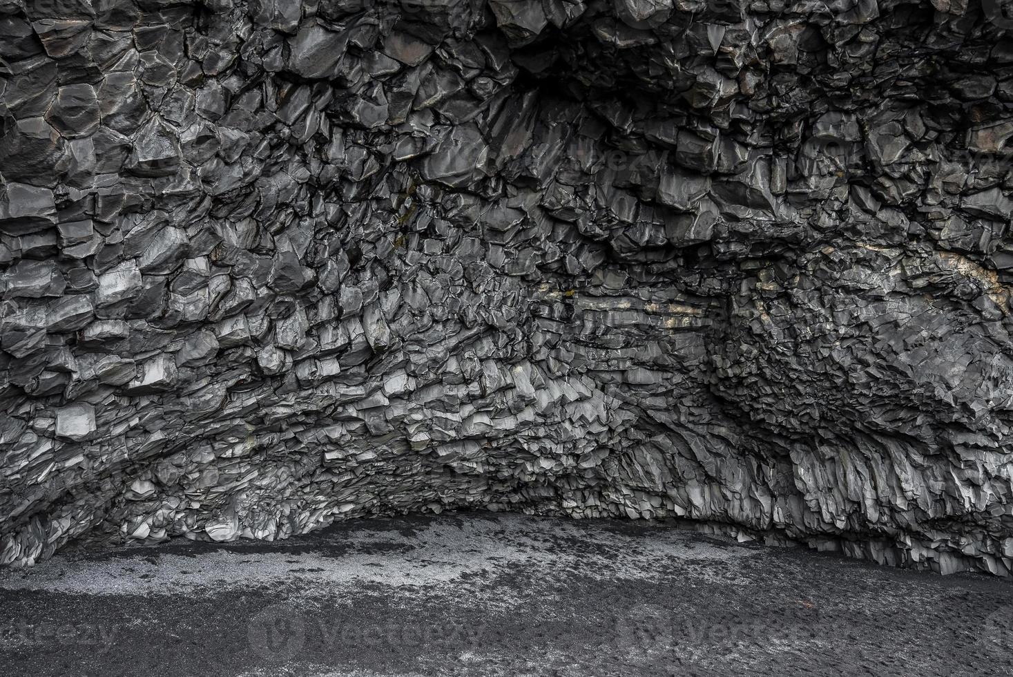 bella formazione di colonne di roccia basaltica sulla spiaggia nera della spiaggia di reynisfjara foto