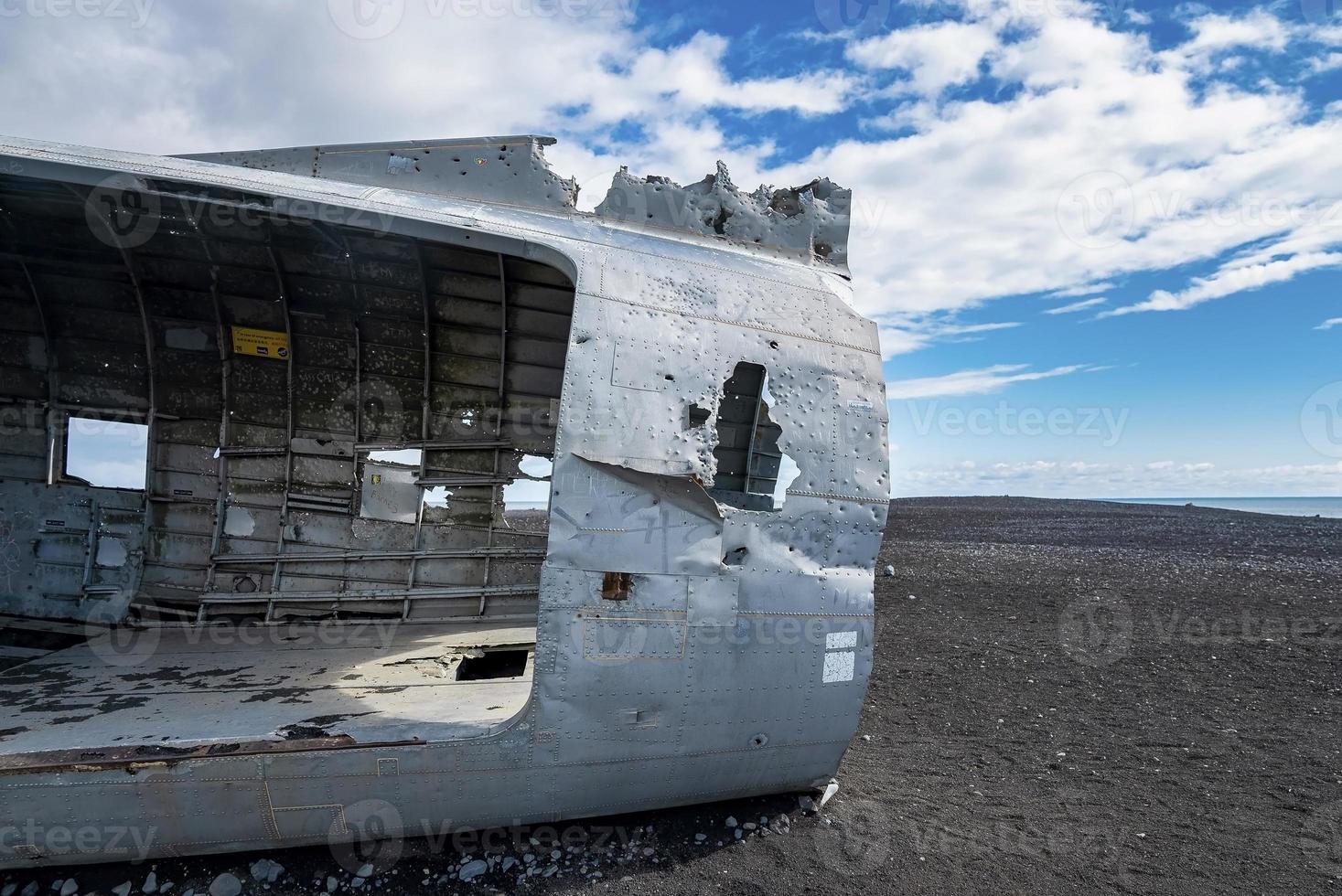 primo piano del relitto dell'aeroplano rotto sulla spiaggia nera di solheimasandur contro il cielo foto