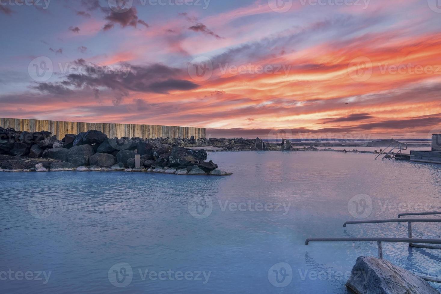 vista della stazione termale geotermica nella laguna blu contro il cielo nuvoloso durante il tramonto foto