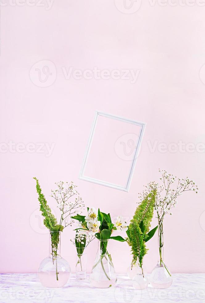 fiori e piante in fiaschetta con cornice. bellissimo sfondo primaverile con fiori in vaso. foto