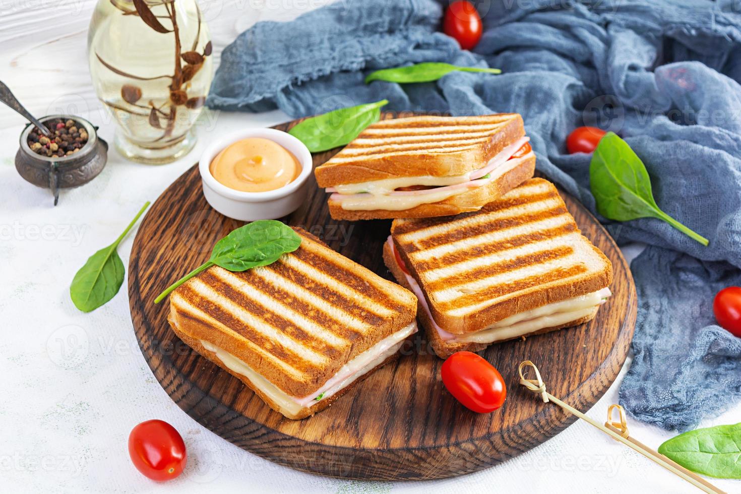 club sandwich con prosciutto, pomodoro, formaggio e spinaci. panini alla griglia foto