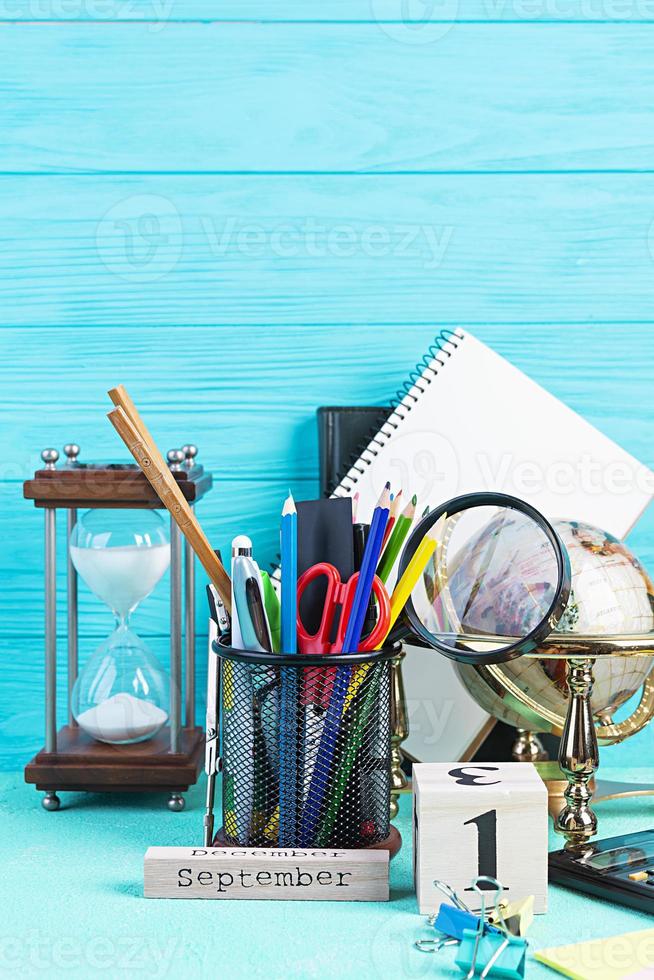 materiale scolastico diverso su sfondo blu. concetto di ritorno a scuola foto