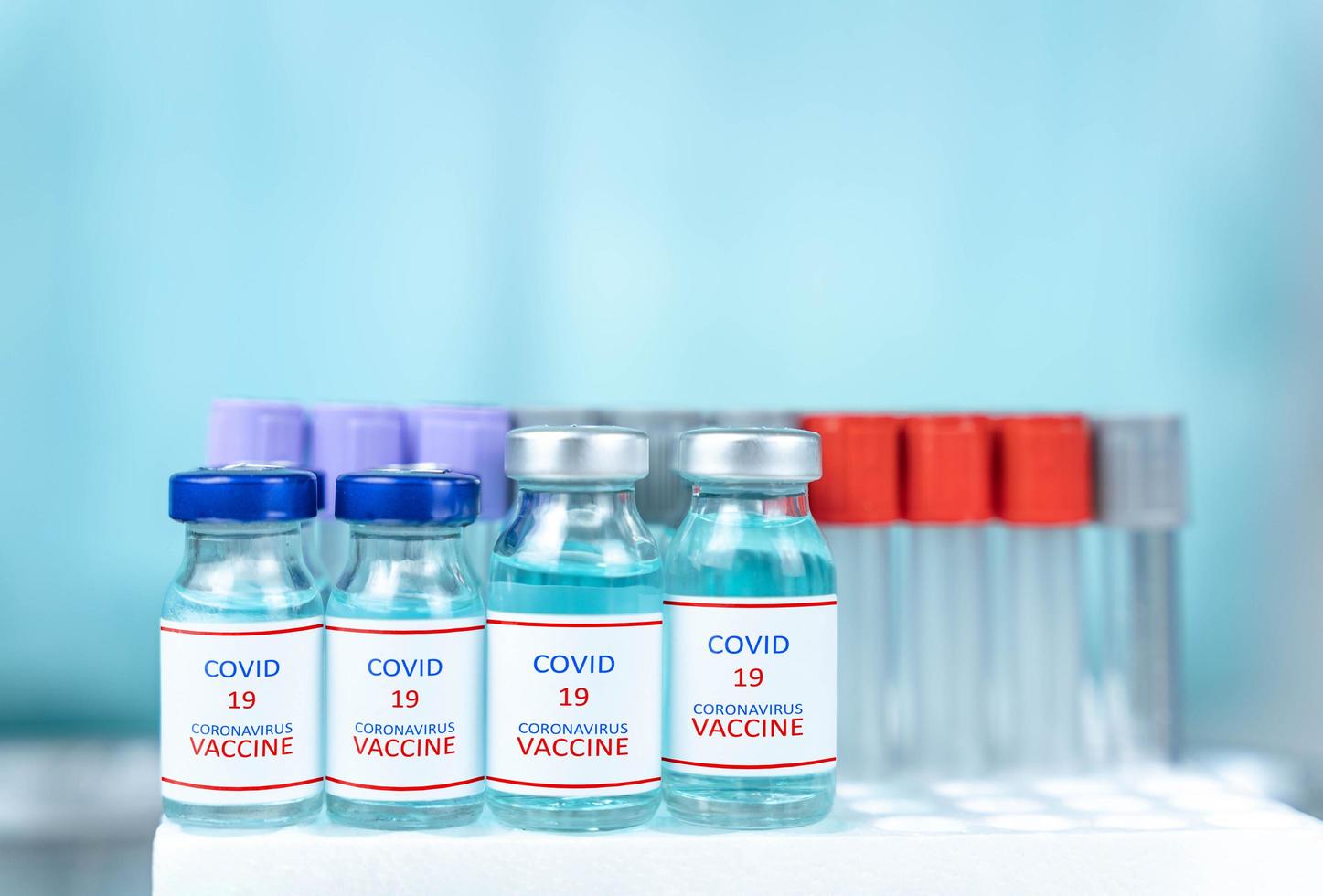 chiudere una bottiglia di vaccino messa sul tavolo dal laboratorio scientifico, un concetto di uso di droghe per trattare e proteggere la pandemia globale di covid-19 foto
