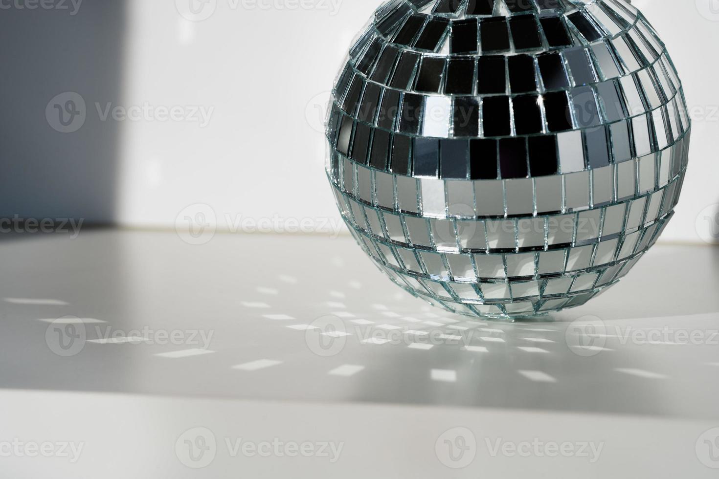 palla da discoteca alla luce del sole su sfondo bianco foto