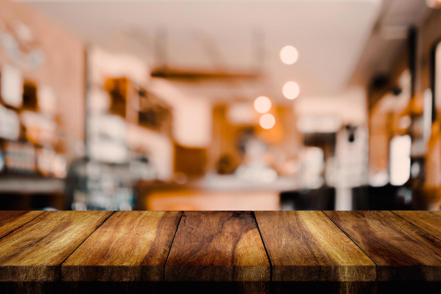 tavolo in legno vuoto con caffetteria interna sfocata o bar per lo sfondo. foto