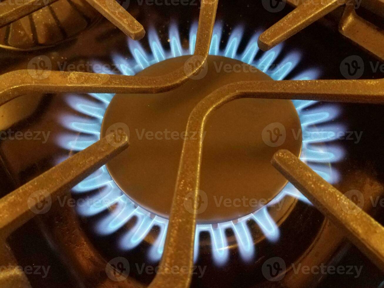 fiamma blu su piano cottura a gas naturale con griglia metallica foto