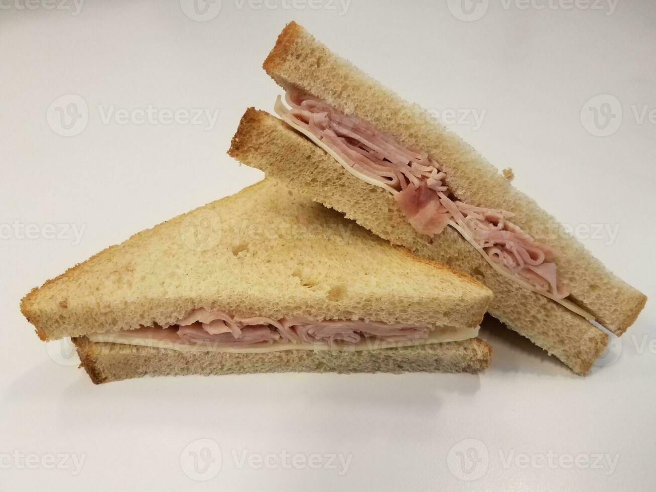 panino al prosciutto e formaggio e pane su superficie bianca o tavolo foto