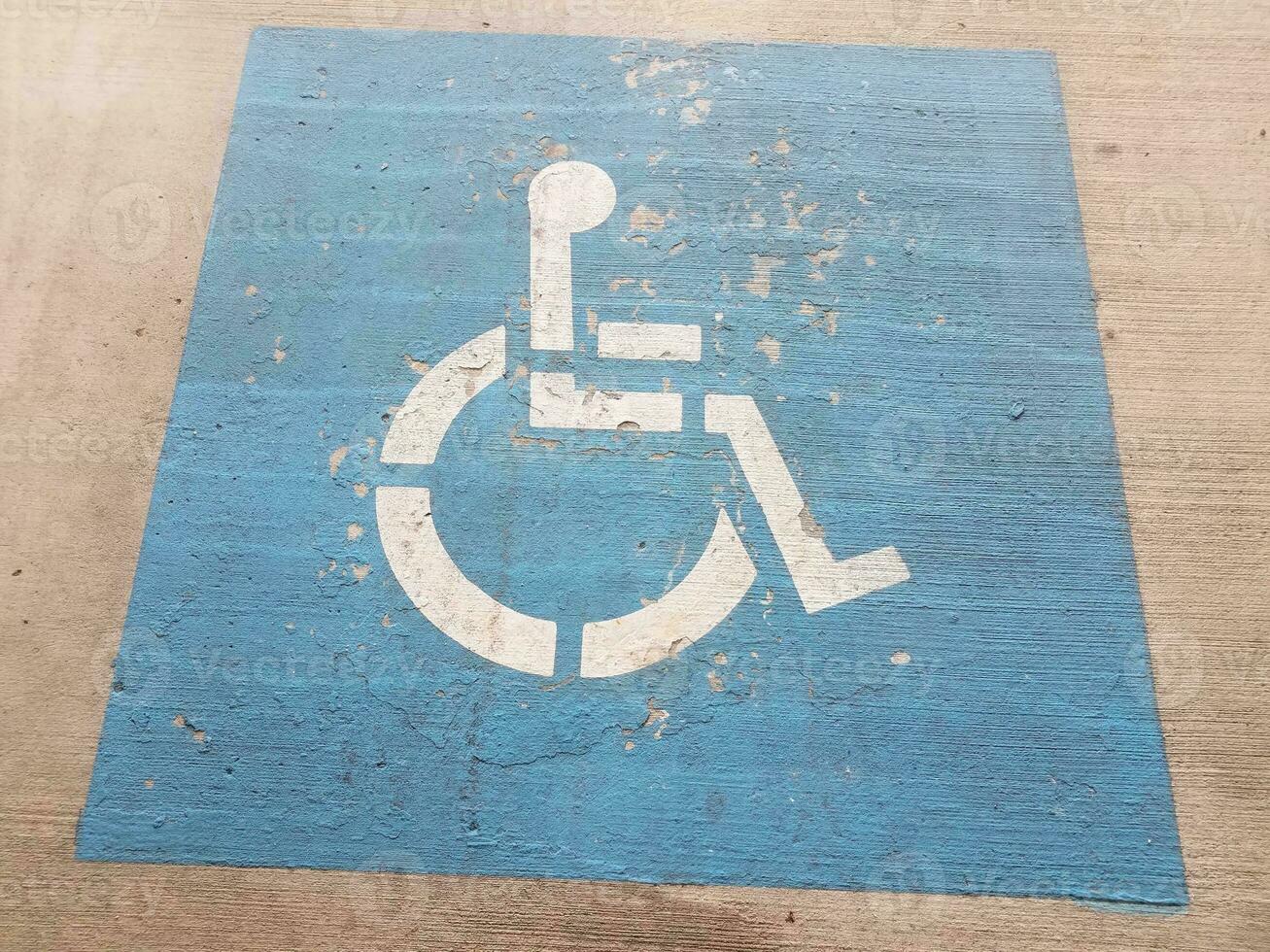 simbolo blu del parcheggio per disabili o sedia a rotelle sul cemento foto