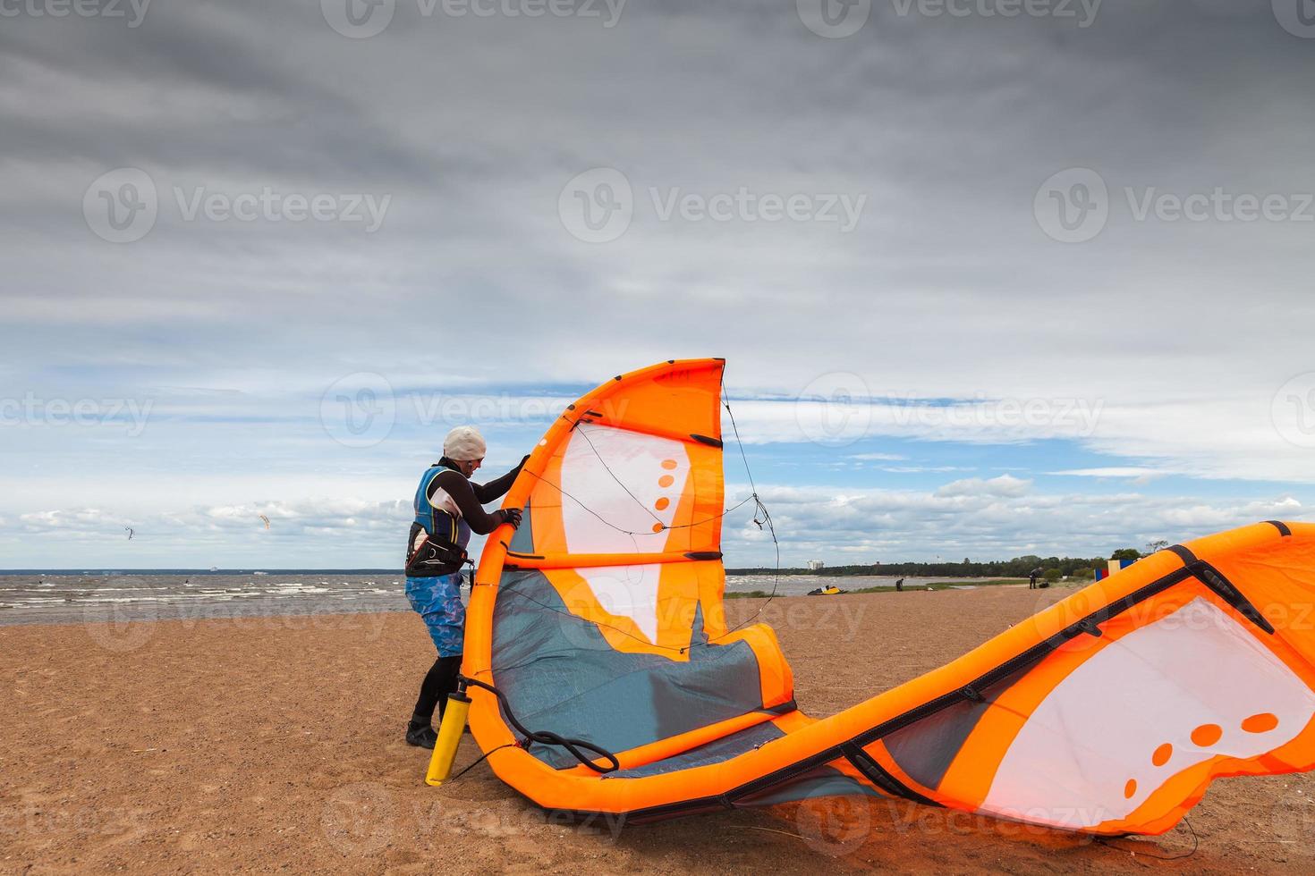 kite surfer sta preparando il suo aquilone in una giornata ventosa foto