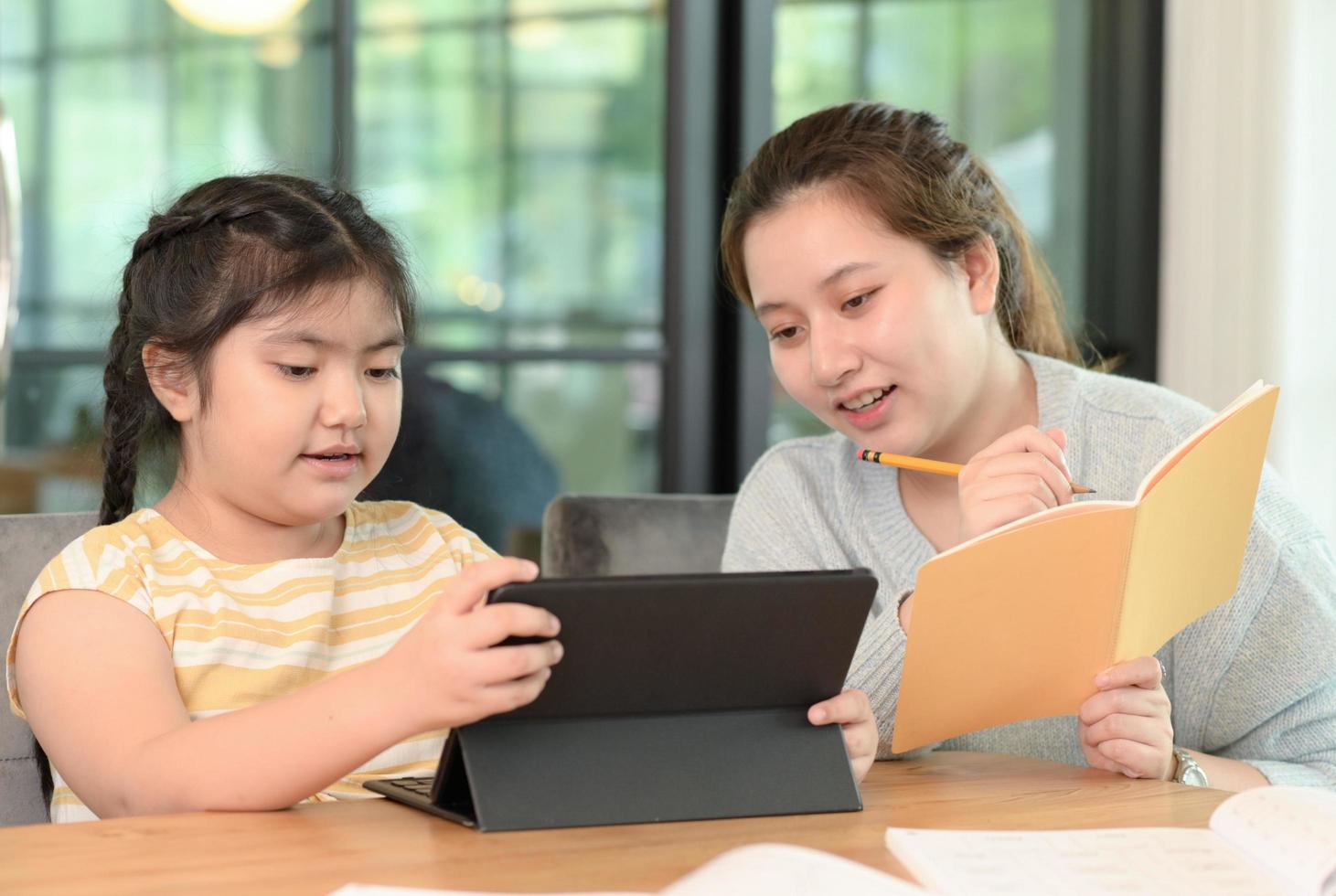 ragazze asiatiche studiano con un tutor, lezioni private a casa, sorelle e sorelle. foto