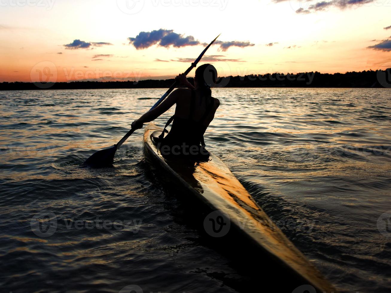 kayaker in acqua contro il tramonto foto