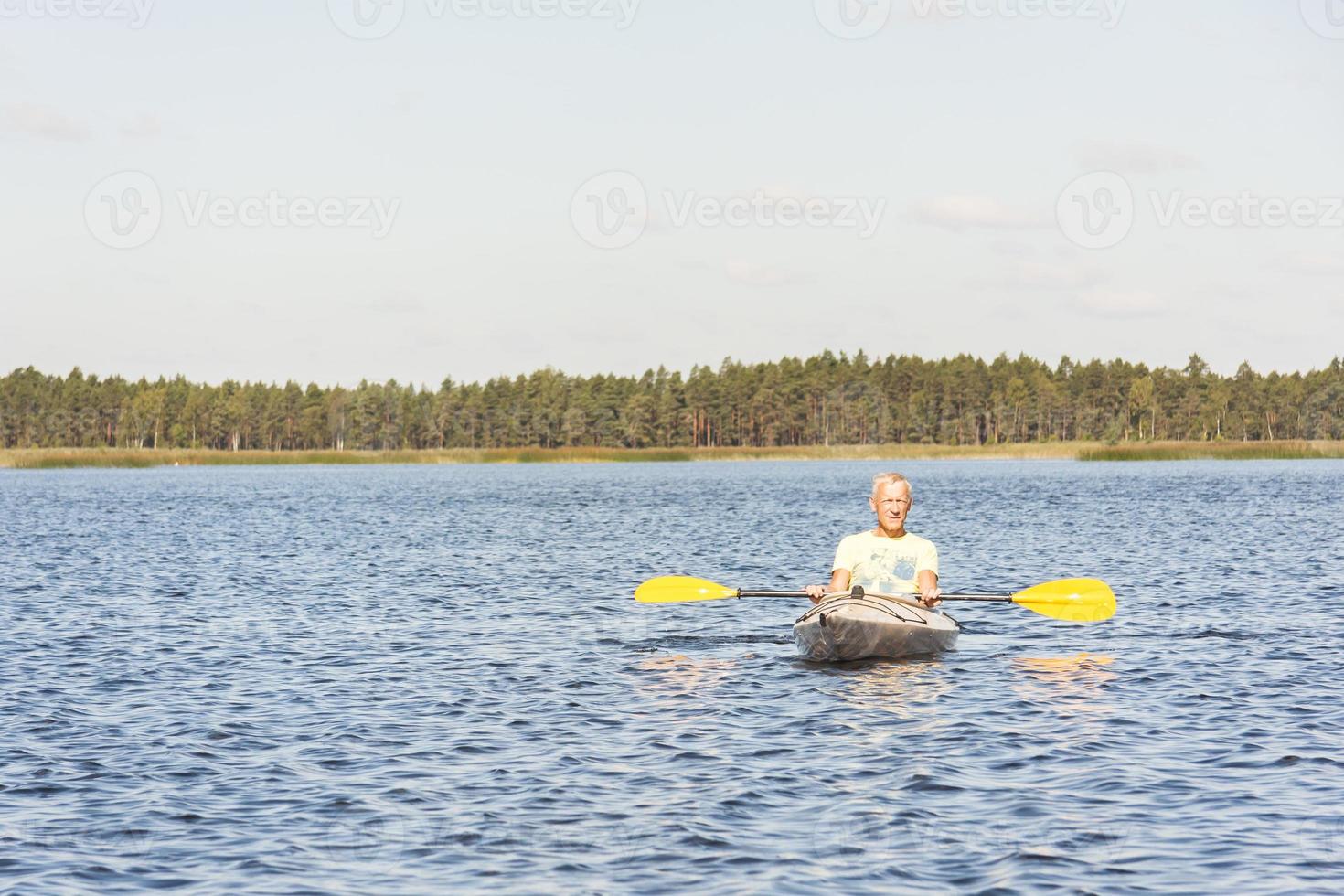 l'uomo sta guidando il kayak in acqua foto