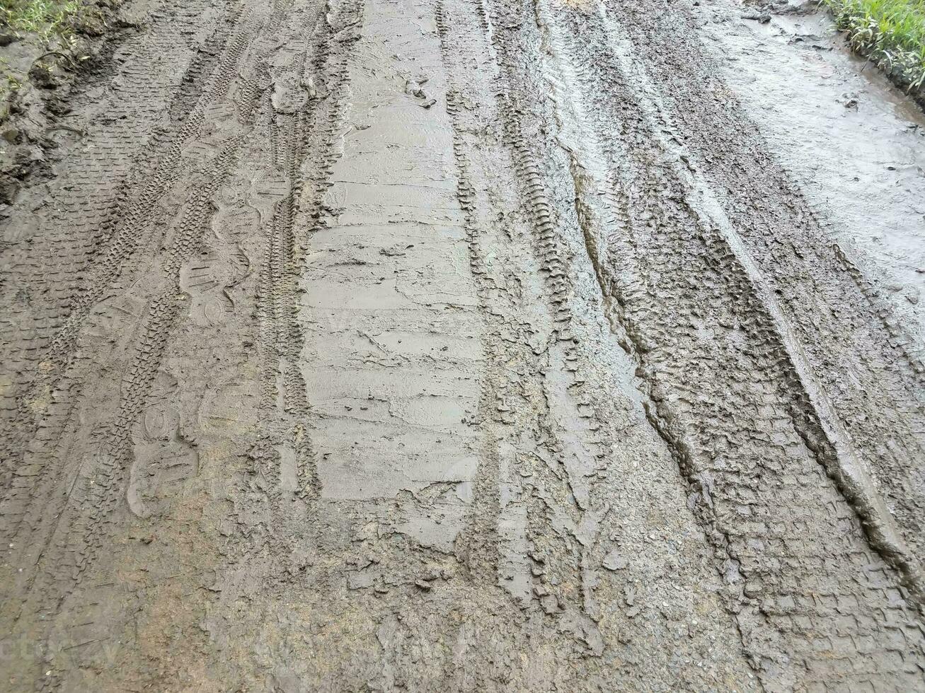 impronte di bici, auto e scarpe nel fango foto