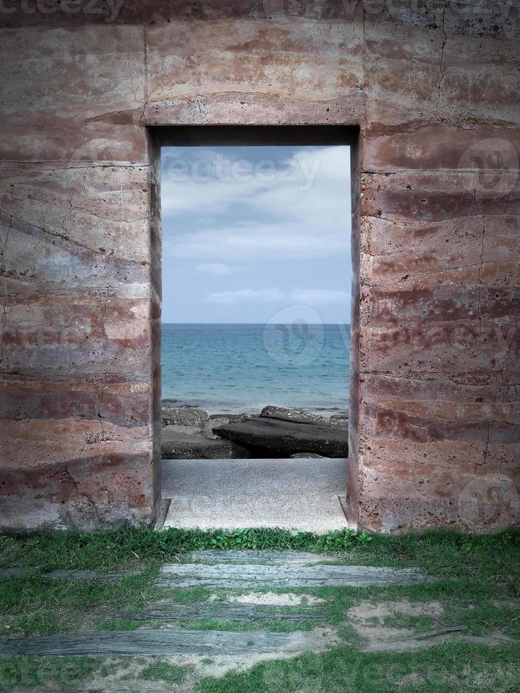 vista sul mare attraverso una finestra di roccia foto