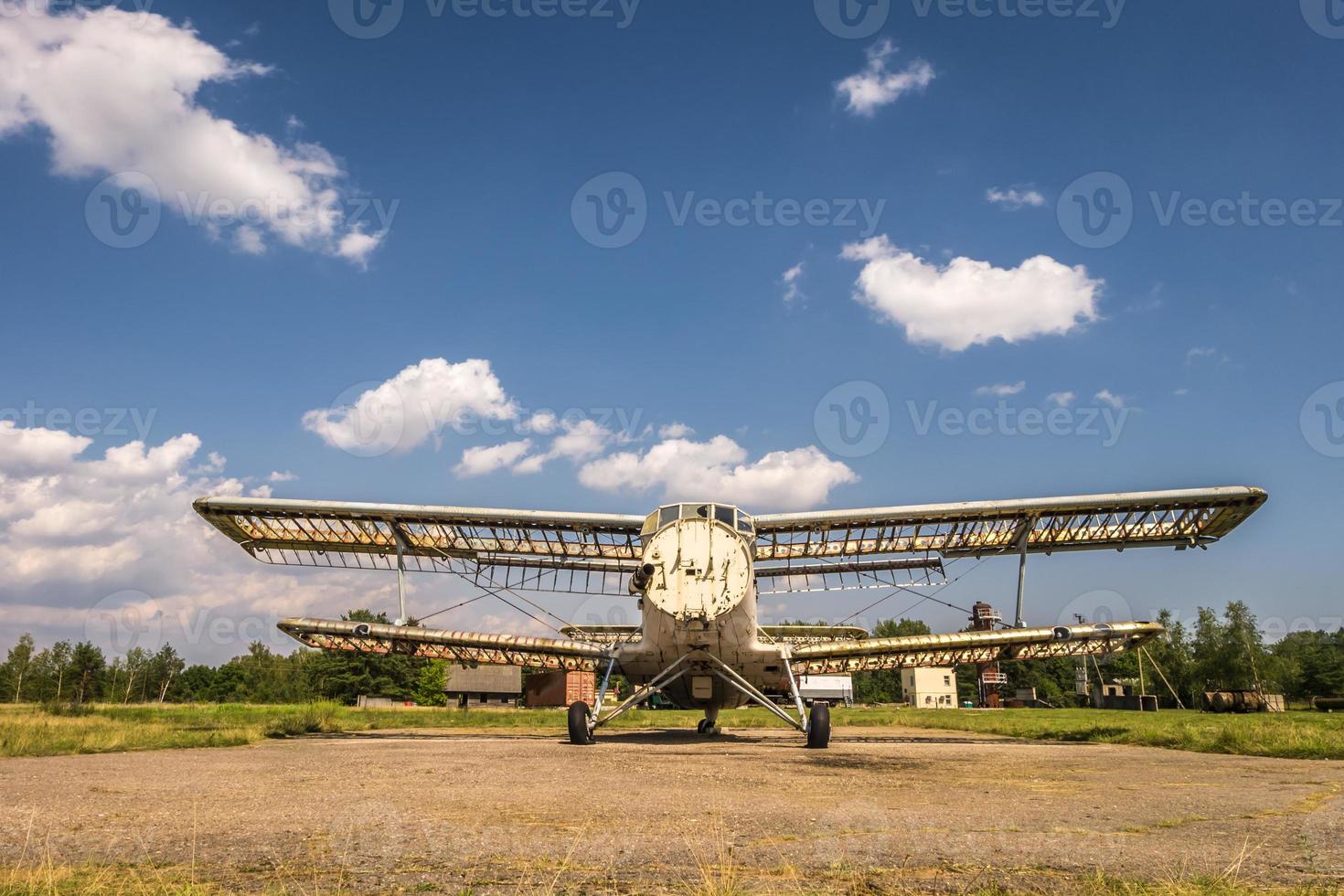 vecchio aereo distrutto nel campo in una giornata di sole foto