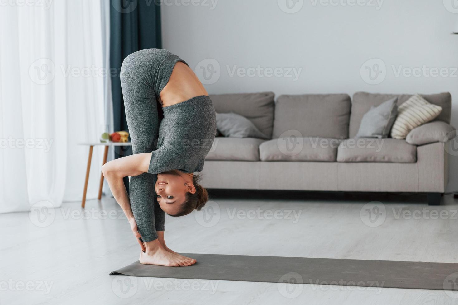 uno stile di vita sano. la giovane donna con un tipo di corpo snello e in abiti da yoga è a casa foto