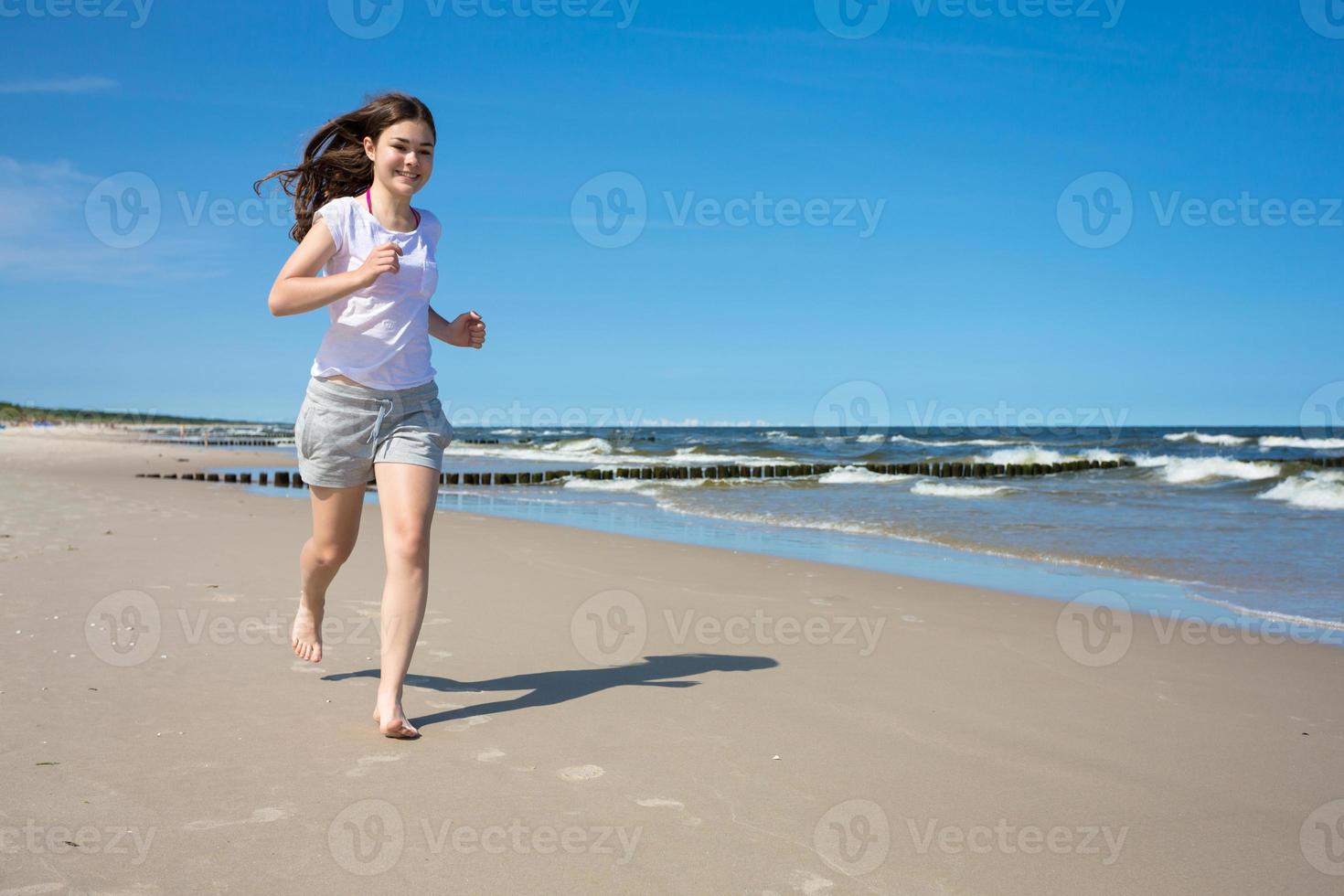 ragazza che corre sulla spiaggia foto