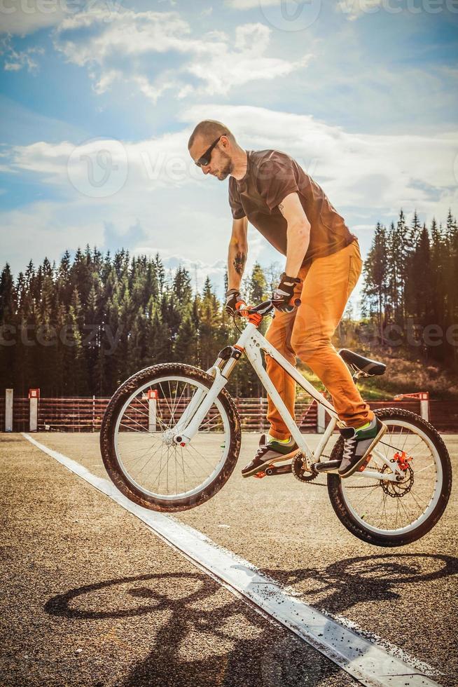l'uomo salta in bicicletta attraverso la linea bianca foto