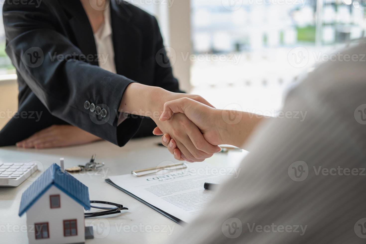 garanzie, mutui, firme, contratto, concetto di accordo, agenti immobiliari stringono la mano ai clienti dopo aver firmato il contratto e si congratulano con loro dopo aver raggiunto un accordo. foto