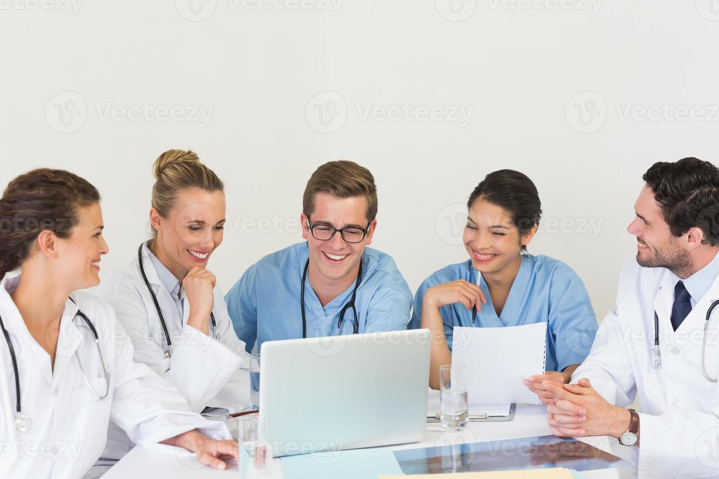 gruppo di medici che discute sopra il computer portatile foto
