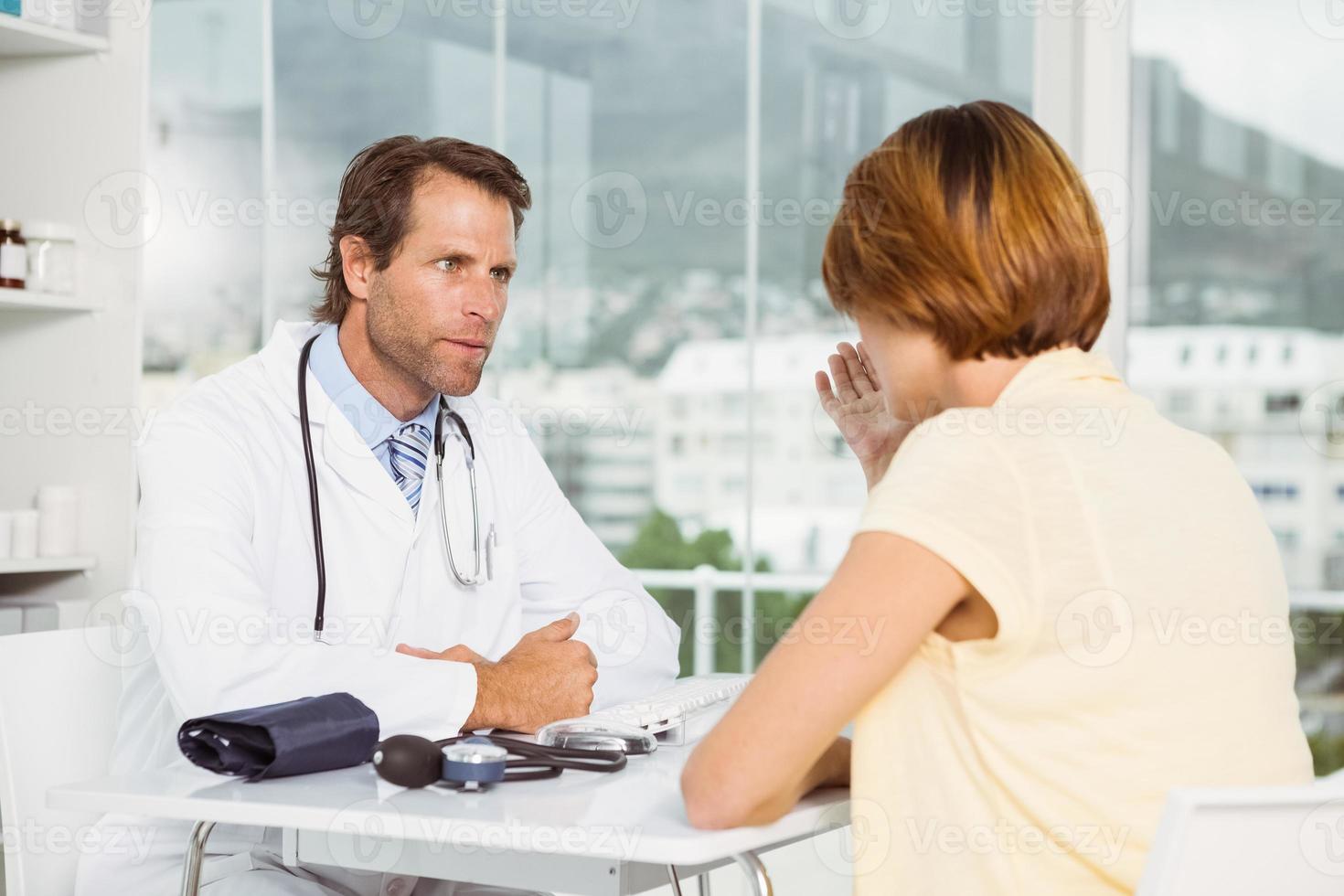 medico in discussione con il paziente presso l'ufficio medico foto