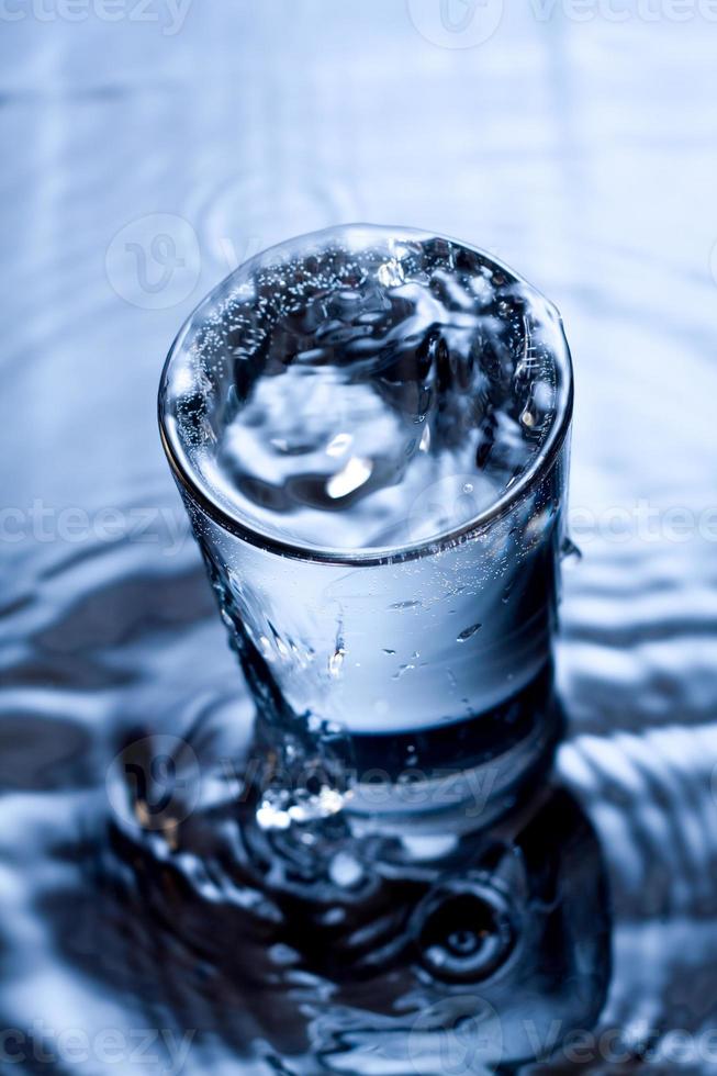 immagine monocromatica blu di schizzi d'acqua in un bicchiere. foto