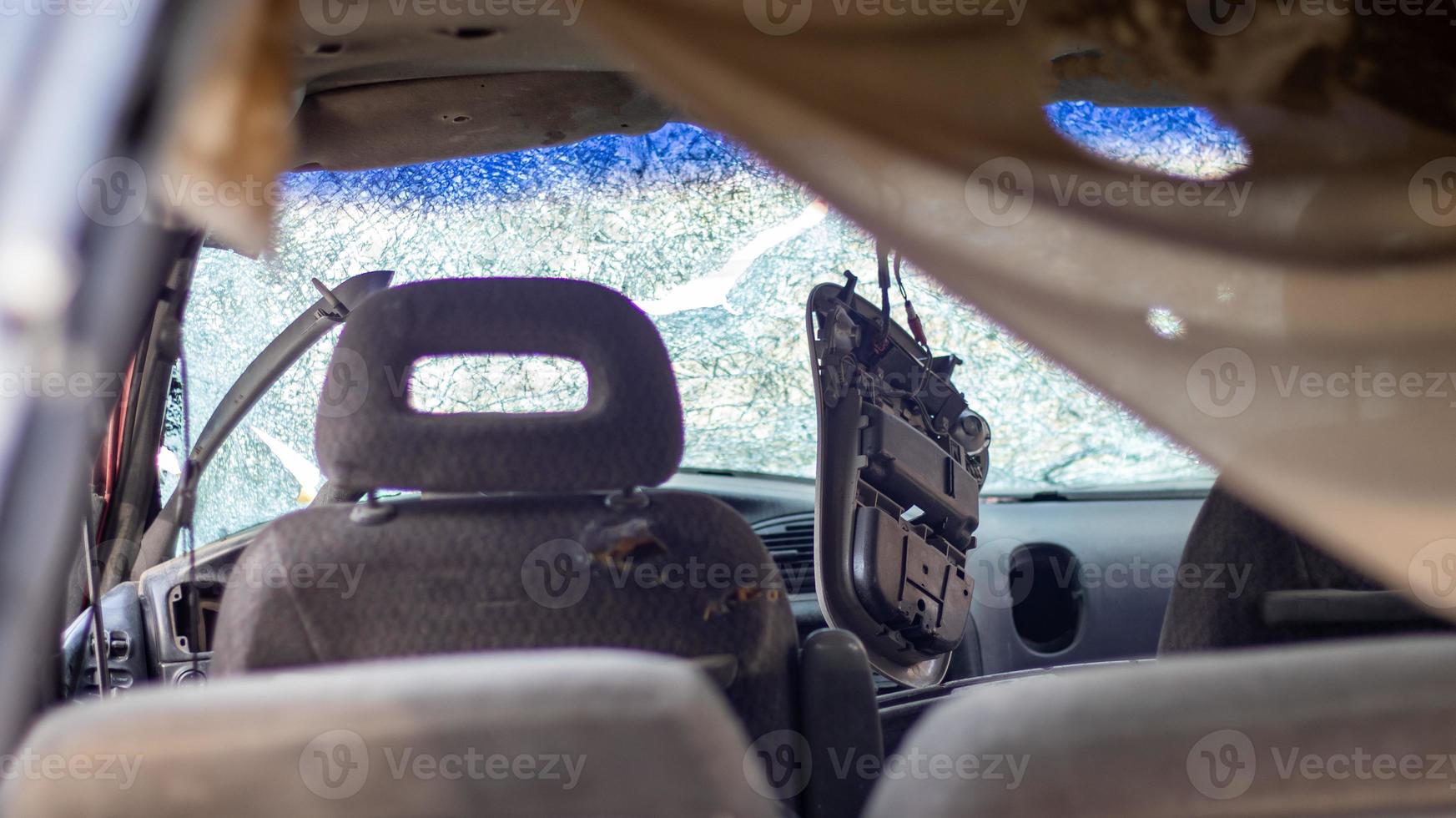 primo piano di un'auto con un parabrezza rotto dopo un incidente mortale. conseguenza di un incidente stradale mortale. guida pericolosa e spericolata. vista dell'interno dell'auto dal lunotto. foto