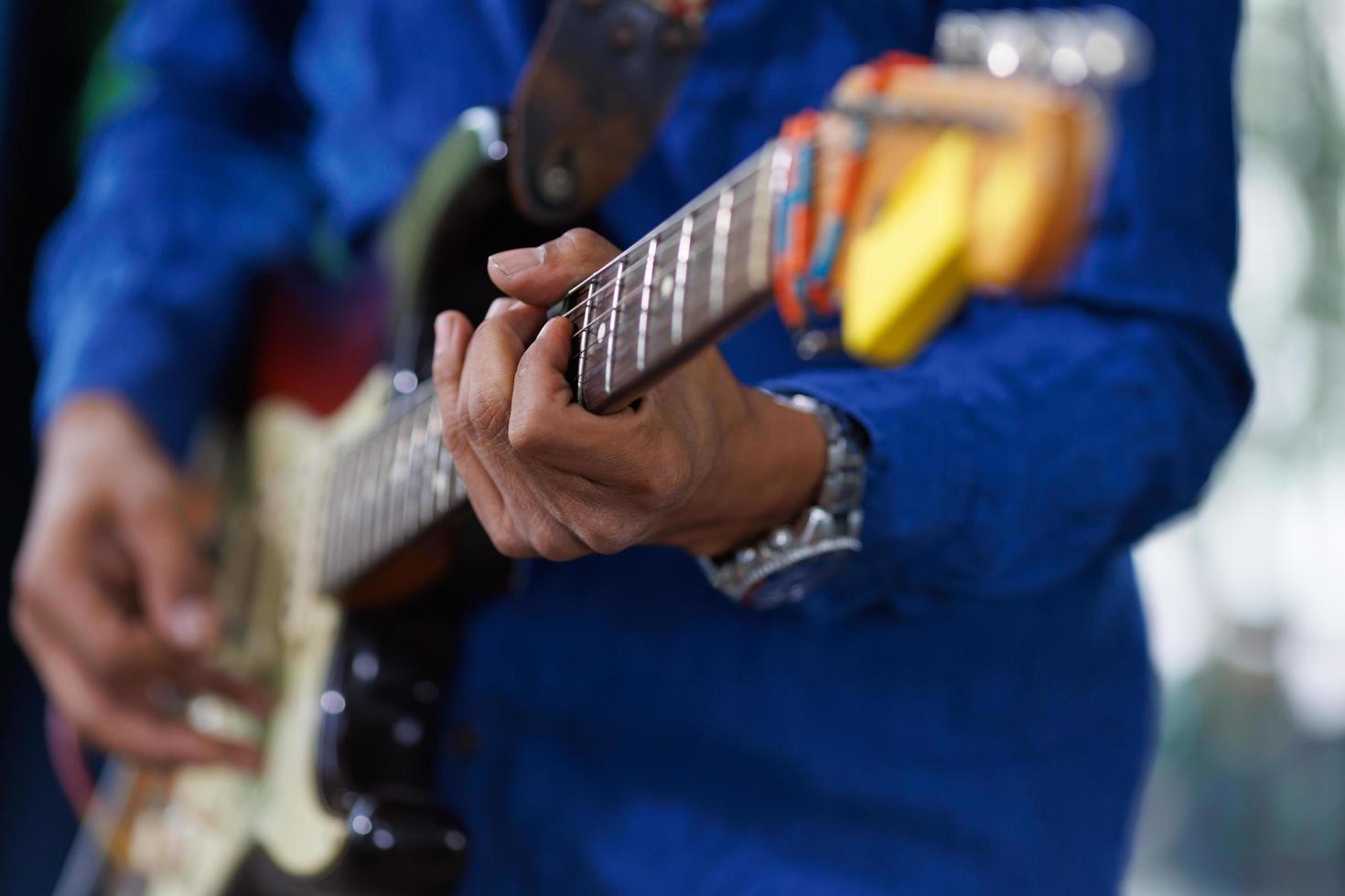 mano dell'uomo che suona la chitarra elettrica. un musicista chitarrista irriconoscibile che esegue musica con uno strumento foto