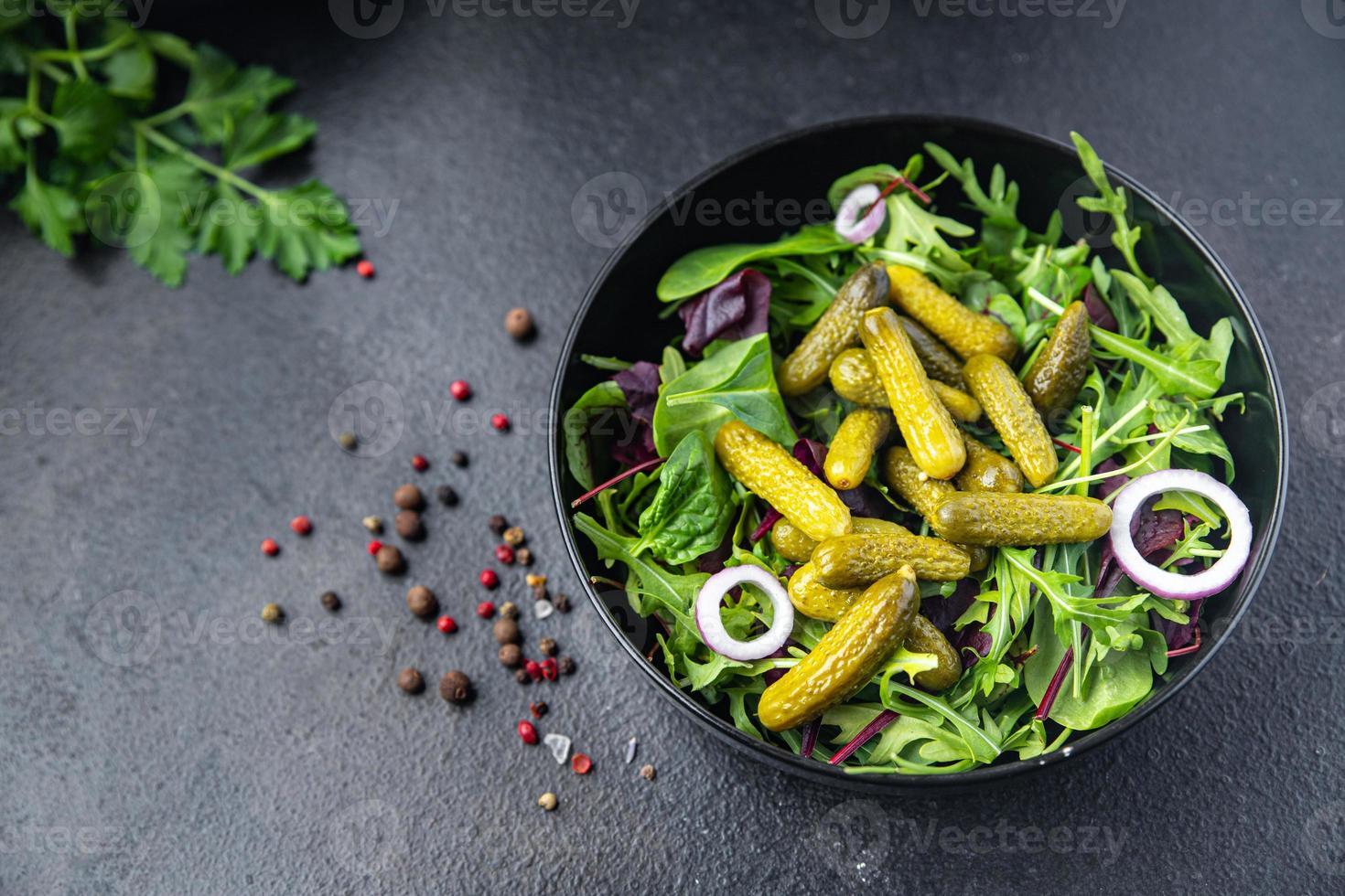 cetriolini insalata cetriolo salato foglie verdi mix pasto fresco spuntino sul tavolo copia spazio cibo sfondo rustico vegetariano vegano foto