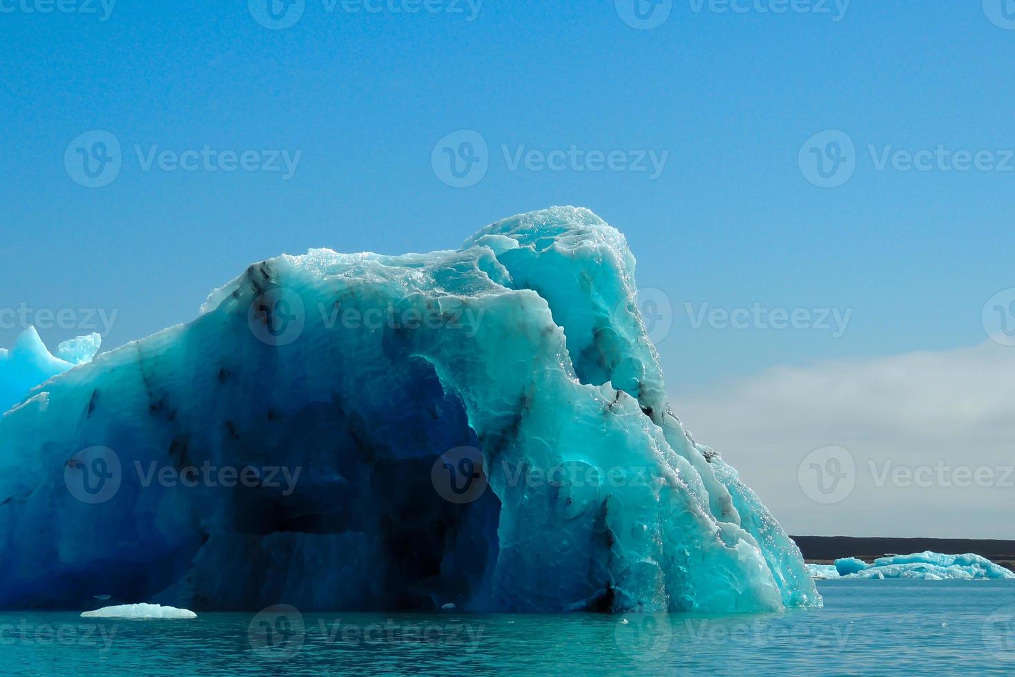 iceberg blu chiaro brillante che galleggia nell'acqua fredda blu del lago jokulsarlon in islanda 6 foto