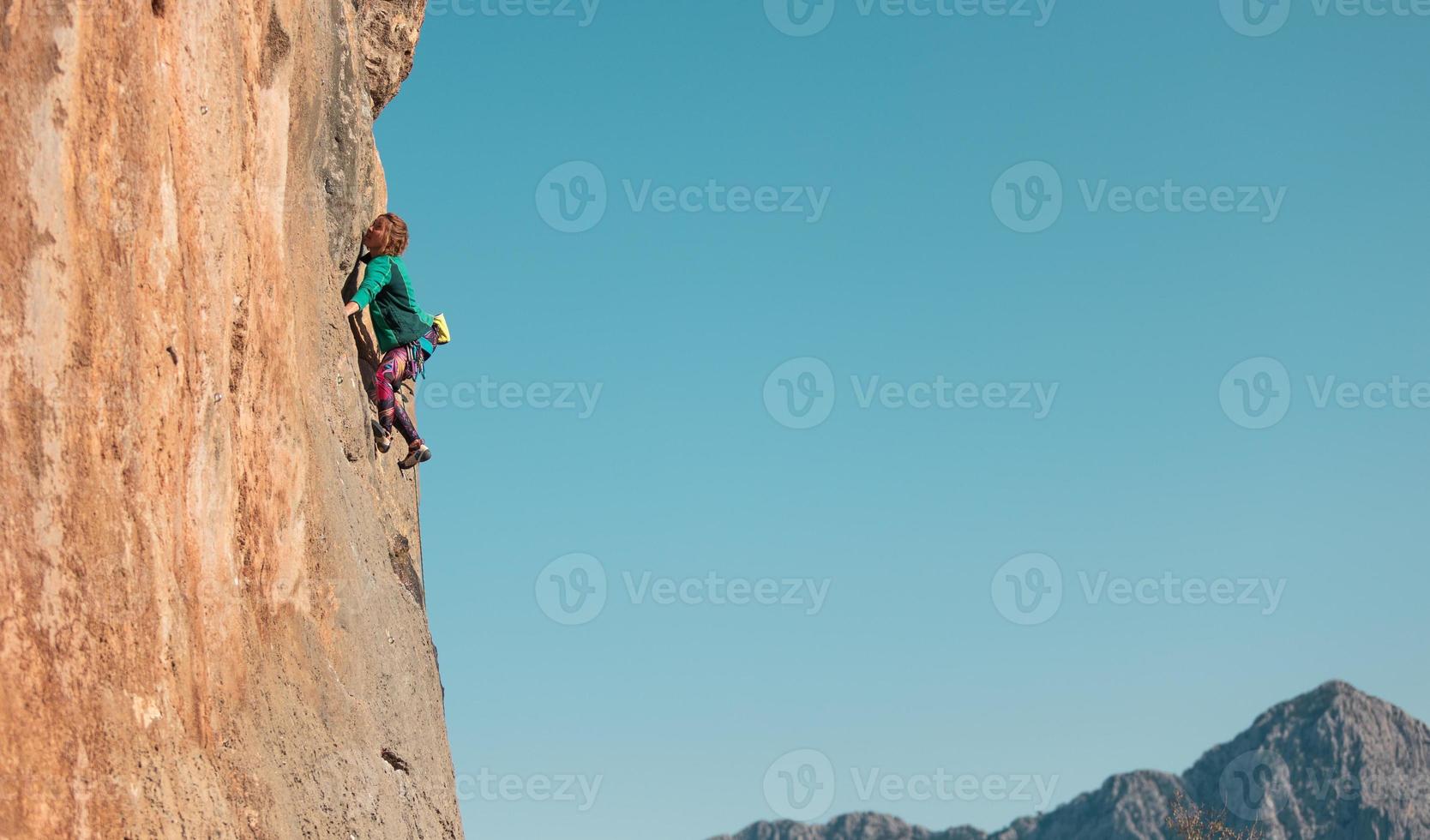 una donna si arrampica su una roccia foto