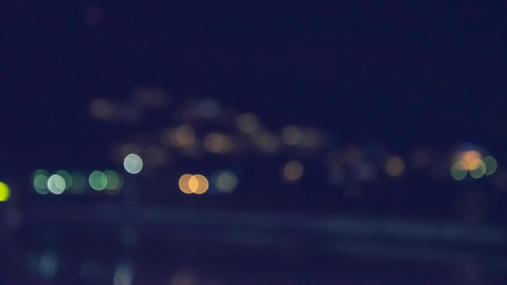 i toni di colore vintage sono immagini astratte e sfocate dei negozi che vendono merci sulla spiaggia di notte con bokeh per l'uso in background. accendi le luci di notte nei festeggiamenti foto